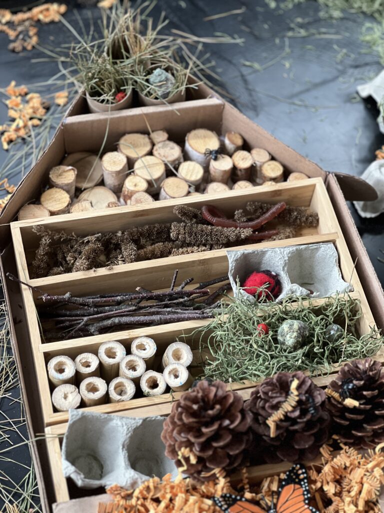 bug hotel activity with bamboo, sticks, stumps and felt ladybug