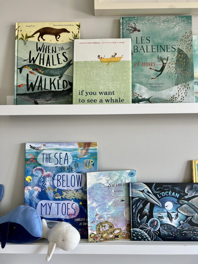 ocean books on shelf with plush whales