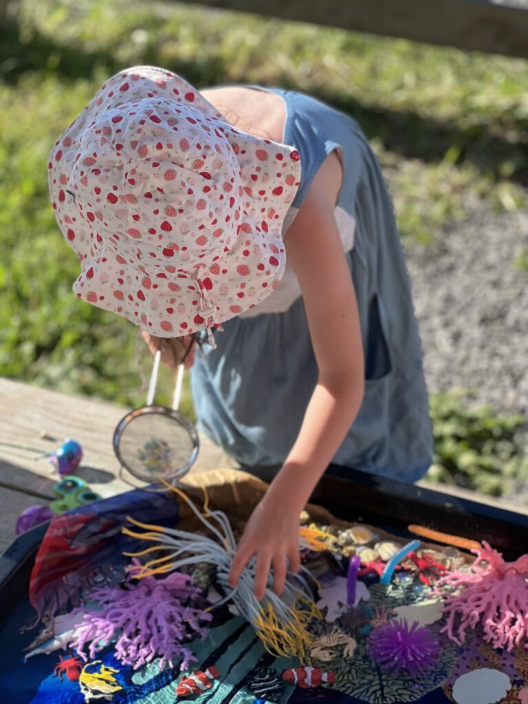 girl playing with small world ocean activity