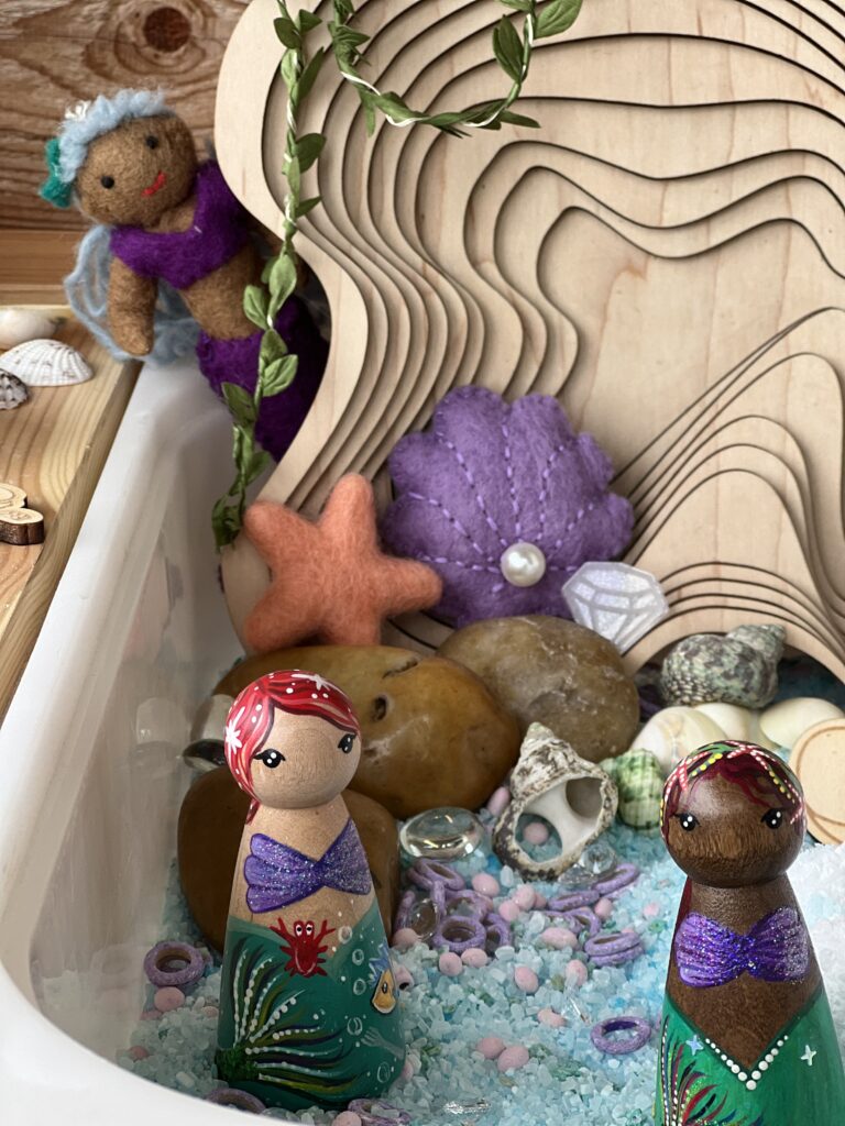 mermaid peg dolls in sensory play bin