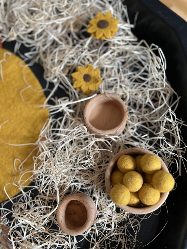 felt balls and sunflowers in fall tuff tray play